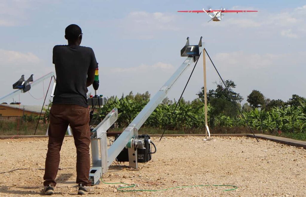 a zipline worker technician launches a drone in muhanga